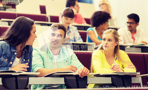 Image of group of students with notebooks in lecture hall