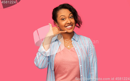 Image of african american woman making phone call gesture