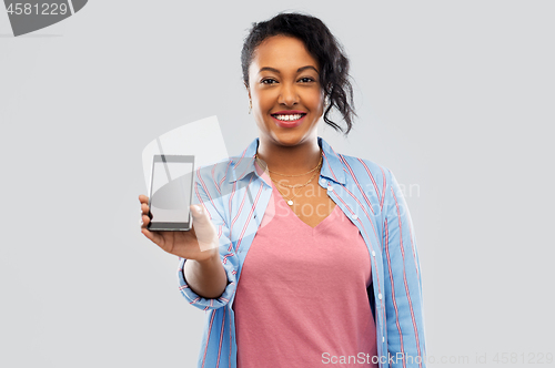 Image of happy african american woman showing smartphone