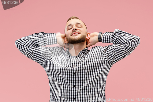 Image of The happy businessman standing and smiling against pink background.