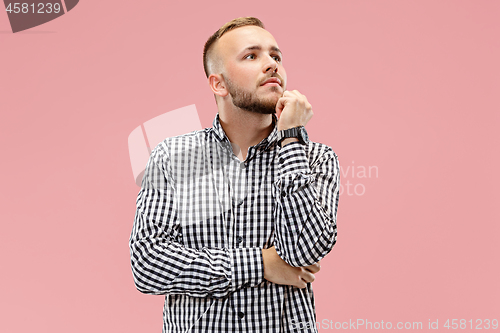 Image of Young serious thoughtful businessman. Doubt concept.