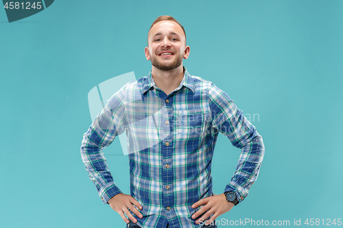 Image of The happy business man standing and smiling against blue background.