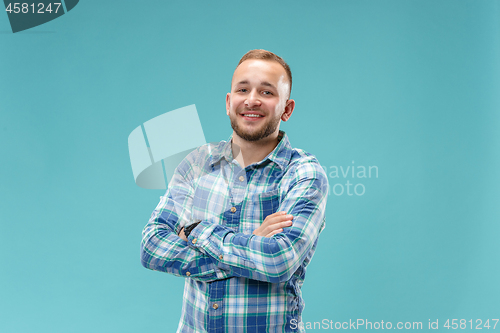 Image of The happy business man standing and smiling against blue background.