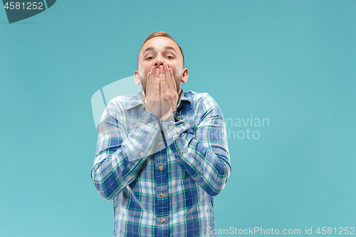 Image of The young attractive man looking suprised isolated on blue