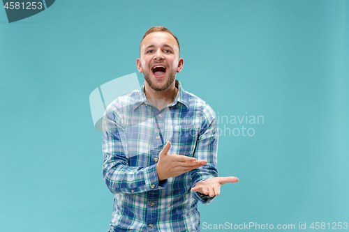 Image of Beautiful male half-length portrait isolated on blue studio backgroud.