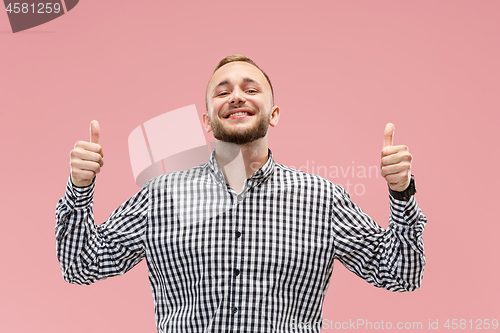 Image of The happy businessman standing and smiling against pink background.