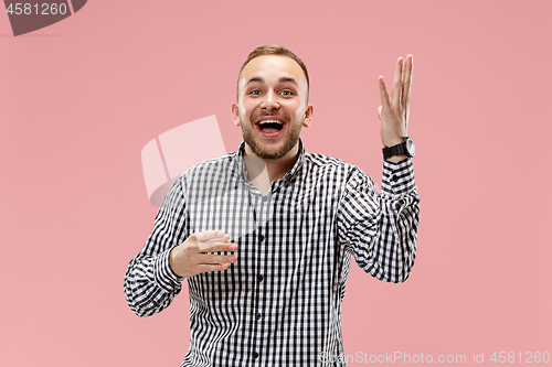 Image of The happy business man standing and smiling against pink background.