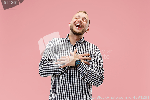 Image of The happy business man standing and smiling against pink background.