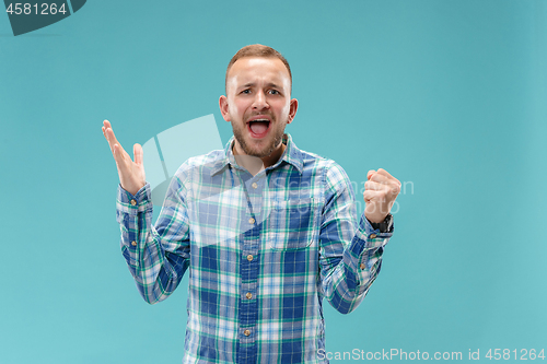 Image of Beautiful male half-length portrait isolated on blue studio backgroud.