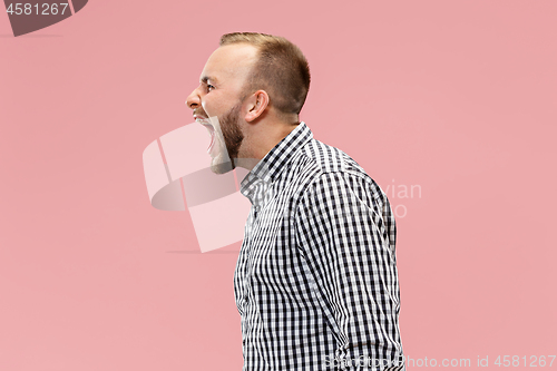 Image of The young emotional angry man screaming on studio background