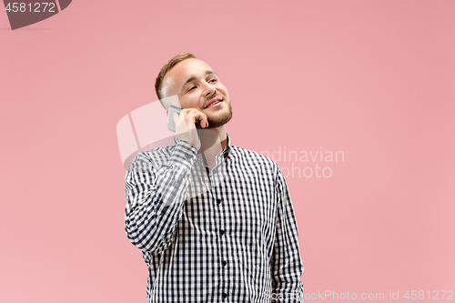 Image of Young handsome man talking over phone and looking away.