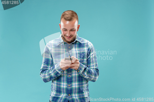 Image of Young handsome man talking over phone and looking away.