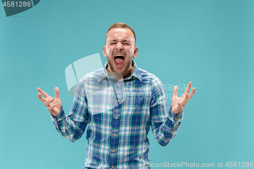 Image of The young emotional angry man screaming on studio background