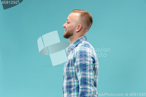 Image of The happy business man standing and smiling against blue background.