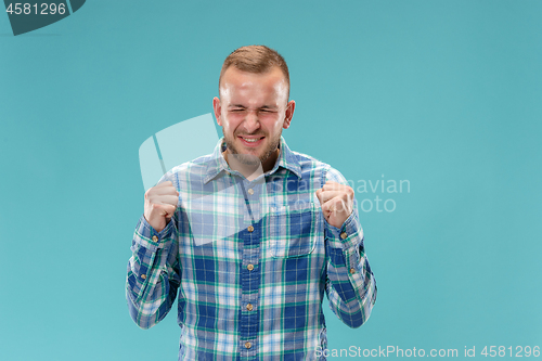 Image of Beautiful man looking suprised and bewildered isolated on blue