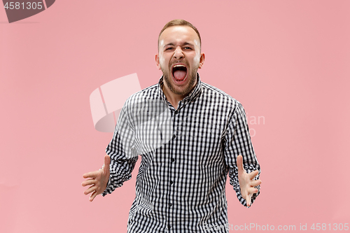 Image of The young emotional angry man screaming on studio background