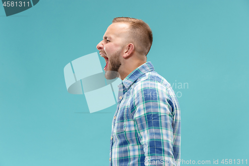 Image of The young emotional angry man screaming on studio background