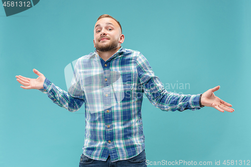 Image of Beautiful man looking suprised and bewildered isolated on blue