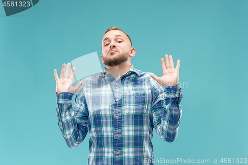 Image of Beautiful man looking suprised and bewildered isolated on blue