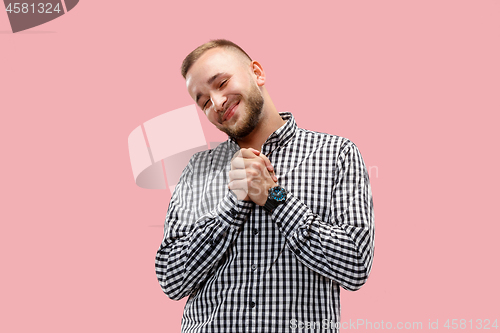 Image of The happy businessman standing and smiling against pink background.