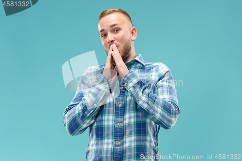 Image of The young attractive man looking suprised isolated on blue