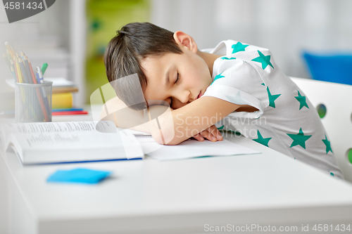 Image of tired student boy sleeping on table at home