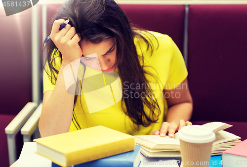 Image of student girl with books and coffee on lecture