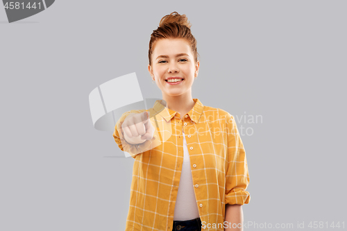 Image of smiling red haired teenage girl in checkered shirt