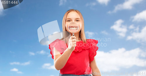 Image of happy girl with magnifying glass over her teeth
