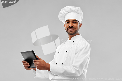 Image of happy male indian chef with tablet computer