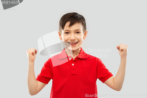 Image of boy in t-shirt showing fists or winning gesture