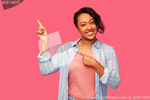 Image of happy african american woman pointing finger up