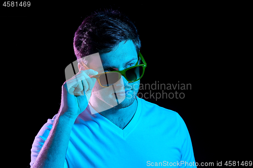 Image of man in sunglasses over ultra violet neon lights