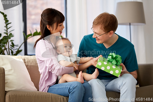Image of mother with baby giving birthday present to father