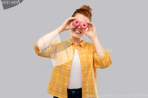 Image of funny teenage girl with donuts instead of eyes