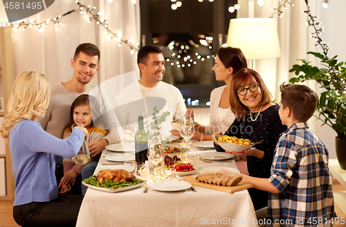 Image of happy family having dinner party at home