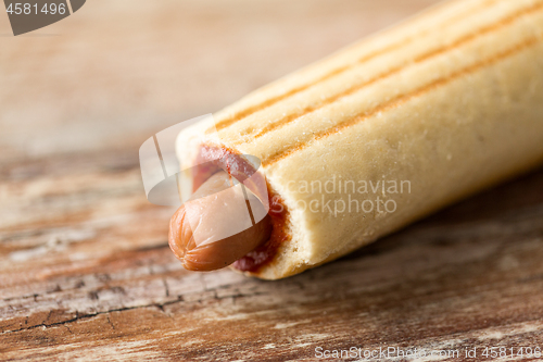 Image of close up of hot dog on wooden table