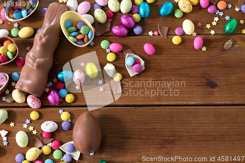 Image of chocolate eggs, easter bunny and candies on wood