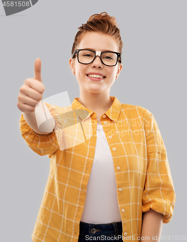 Image of redhead student girl in glasses showing thumbs up