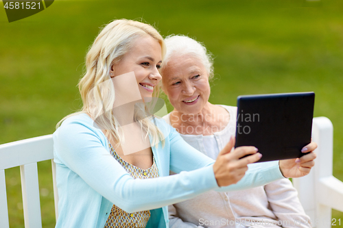 Image of daughter with tablet pc and senior mother at park