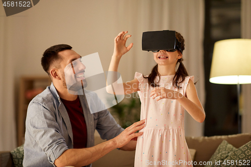 Image of father and daughter in vr glasses playing at home