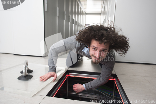 Image of engineer connecting cables in server room