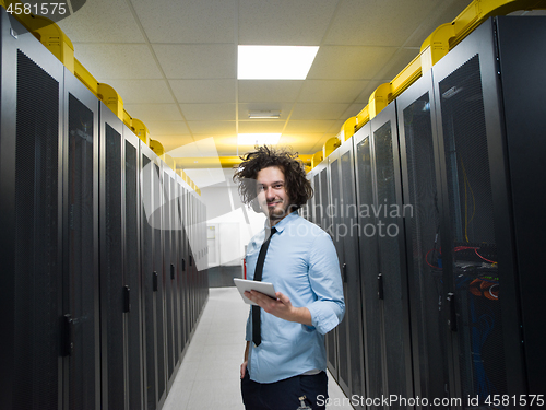 Image of IT engineer working on a tablet computer in server room