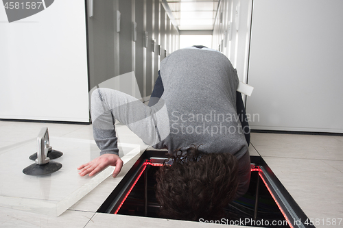 Image of engineer connecting cables in server room