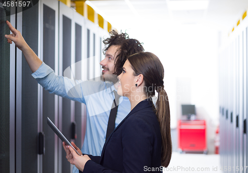 Image of engineer showing working data center server room to female chief