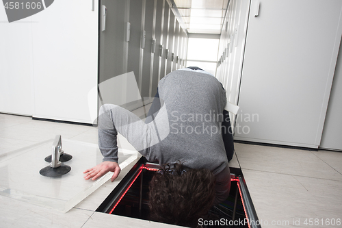 Image of engineer connecting cables in server room