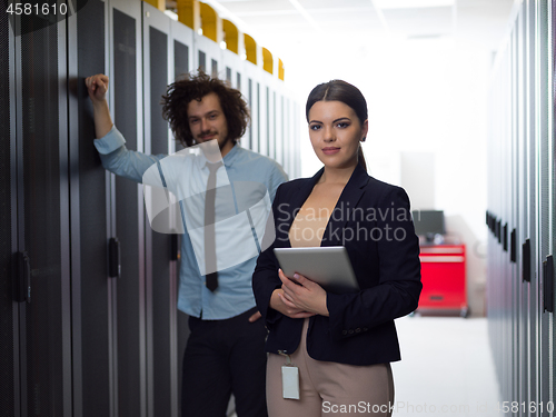 Image of engineer showing working data center server room to female chief