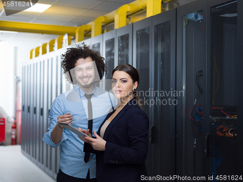 Image of engineer showing working data center server room to female chief