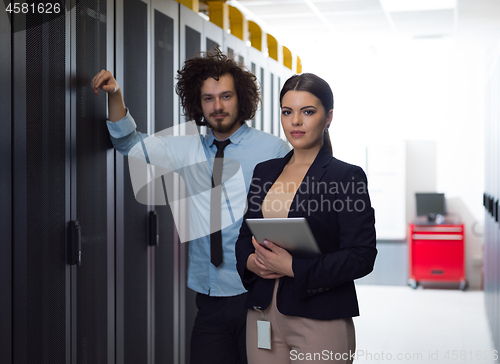 Image of engineer showing working data center server room to female chief