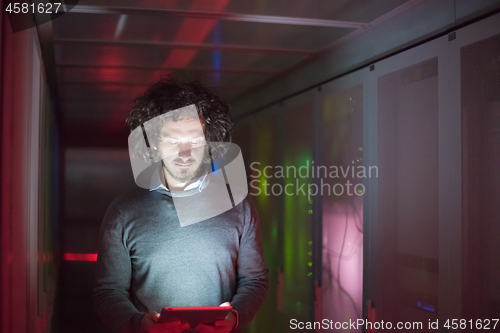 Image of IT engineer working on a tablet computer in server room